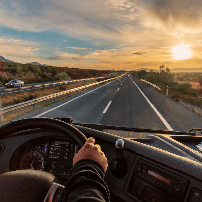A man driving a truck in late afternoon in South Africa on a motorway